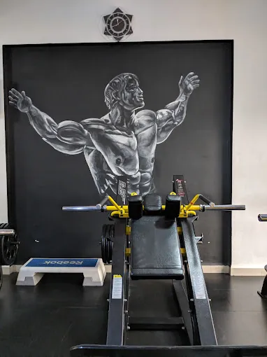 Leg press machine in front of a bodybuilder mural